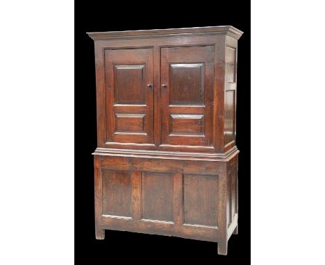 A JOINED OAK LIVERY CUPBOARD, EARLY 18TH CENTURY the upper section with a pair of two-panel doors, and the base with a three-