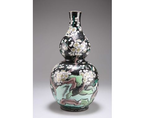 A CHINESE FAMILLE NOIRE ENAMELLED DOUBLE GOURD VASE 19th Century, decorated with flowers, (drilled). 28cm highThe black ename