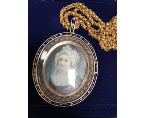 A fine quality Georgian gold memorial pendant, the rose-coloured frame with blue and white enamel, with a braid of hair aroun