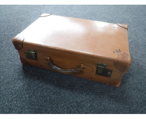 A vintage leather luggage case together with an early 20th century frameless bevelled mirror