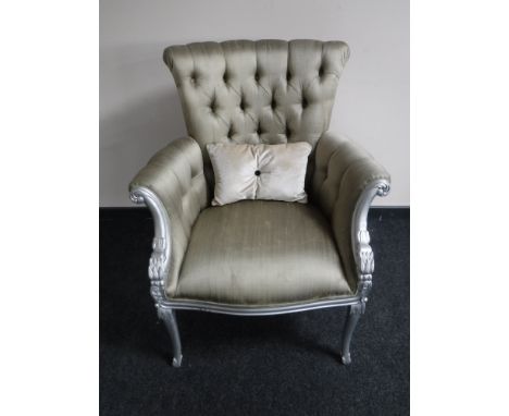 A silvered framed scroll arm armchair, upholstered in a button fabric 