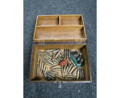 A wooden trinket box containing spent gun shells and a vintage reloading tool 