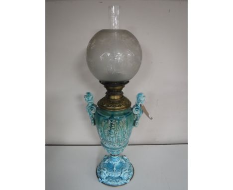 A Victorian glazed pottery oil lamp with chimney and shade