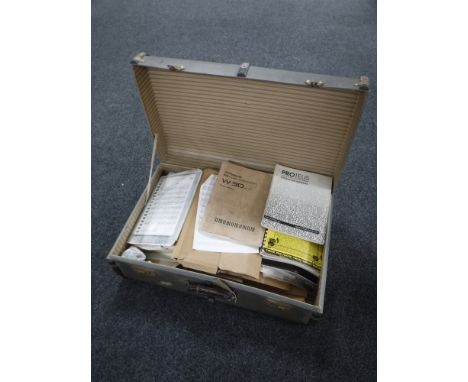 A vintage luggage case containing a quantity of sheet music