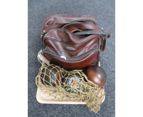 A vintage lawn bowls bag containing five composite lawn bowls and two wooden lawn bowls 