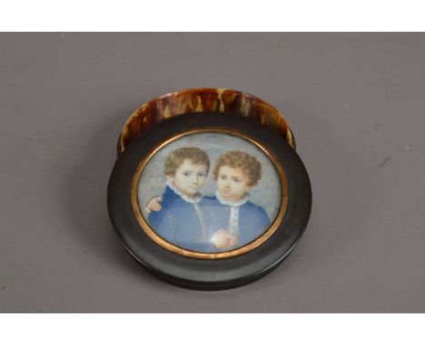 A 19th century portrait miniature of two boys, both wearing blue jackets, inset into a possibly later tortoise shell patch bo