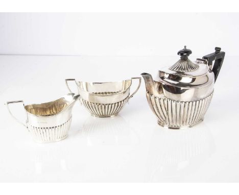 A harlequin Victorian and later silver bachelor's three piece tea set, 16.75 ozt, helmet shaped with fluted lowers (3)