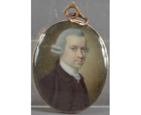 A 19th century Portrait miniature locket on ivory of a Georgian man, with a grey wig and red coat, in a gilt metal oval frame