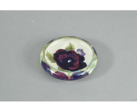 A Moorcroft pottery small dish, c.1914, in a pansy pattern, impressed 'Moorcroft Burslem' and the pattern number 1410, and si