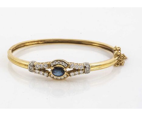 A contemporary sapphire and diamond hinged oval bangle, the mixed cut oval sapphire surrounded by brilliant cut claw set and 