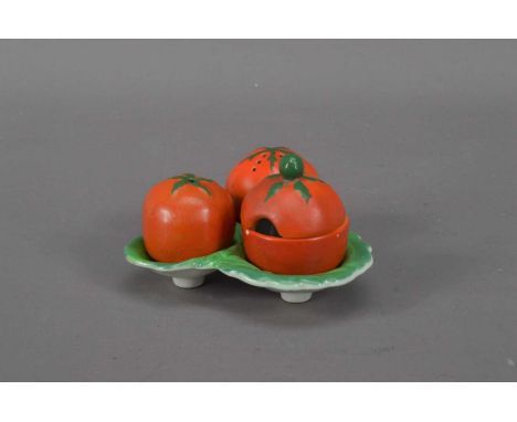 An early 20th century ceramic Carlton Ware novelty three-piece cruet set, in the form of tomato's on a leaf shaped base, some