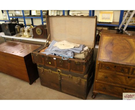 A canvas and battened travelling trunk; a large metal bound travelling trunk; and a quantity of curtains and textiles