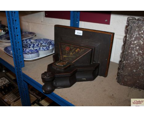 An antique painted clock bracket decorated with heraldic crest and painted foliage 