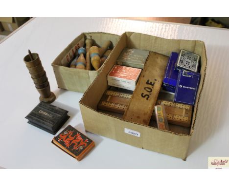 A box containing vintage playing cards; cribbage board; table skittles etc