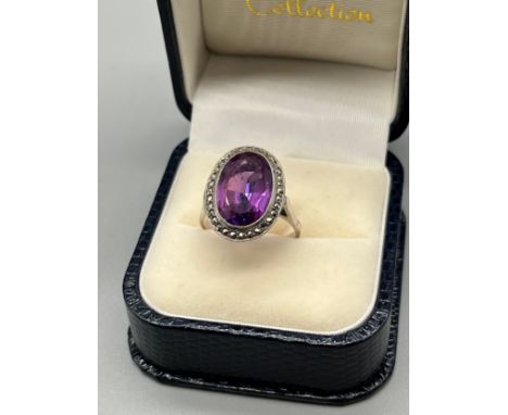 A ladies white metal [foreign stamped] Art Deco ring set with a large Amethyst stone surrounded by Marcasite stones. [Ring si