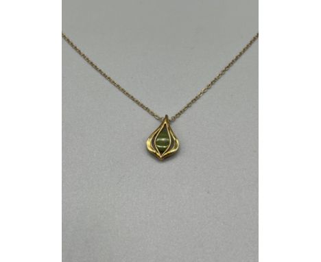 A 9ct gold pendant set with a jade stone and a 9ct gold necklace. [3.10grams] 