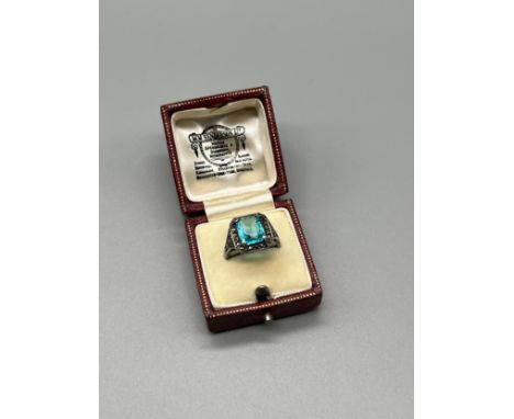 A Ladies Silver Art Deco Ring set with a large blue aquamarine style stone surrounded by marcasite stones. [Ring Size M] [Mis