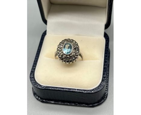 A Ladies 9ct on silver Art Deco ring set with a single aquamarine style stone surrounded by Marcasite stones. [Ring size O] 