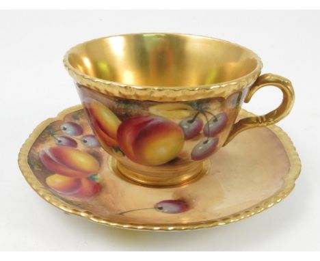 A Royal Worcester tea cup and saucer, the cup and saucer hand painted with fruit to a mossy background to the exterior by Rob
