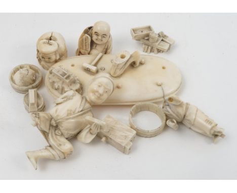 A 19th century carved ivory figure group, of a kneeling male figure and child with wood working tools, mounted on an oval bas