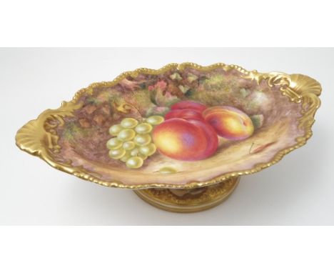 A Royal Worcester oval tazza, hand painted with fruit to a mossy ground by H Ayrton, with shaped gilt edge, raised on a circu