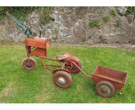 A Tri-Ang tin tractor major, painted red, having three wheels and crane arm to the front, together with trailer
