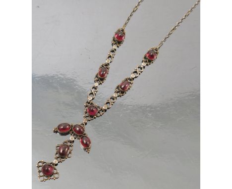 An Arts and Crafts garnet necklace, attributed to the Artificers Guild, the cabochon set frontispiece with a similarly set dr