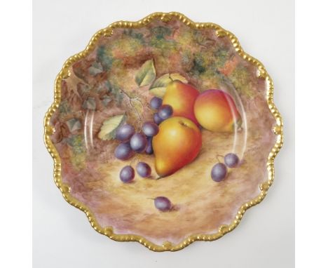 A Royal Worcester cabinet plate, decorated with fruit to a mossy background by H Ayrton, with shaped gilt edge, diameter 9ins