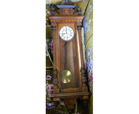 A 19th century walnut cased Vienna style wall clock, with white enamel dial and Roman numerals, the pediment with an arch and