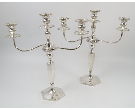 A pair of loaded silver three light candelabra, with bead edge to the sconce and drip tray, two scroll branches, with hexagon