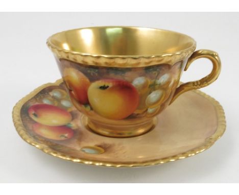 A Royal Worcester tea cup and saucer, the cup and saucer hand painted with fruit to a mossy background to the exterior by Rob