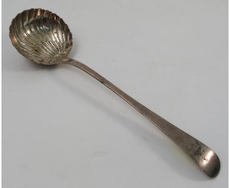 A Georgian silver ladle, with shell bowl, bright cut decoration and engraved with a crest, London 1775, maker George Smith (I