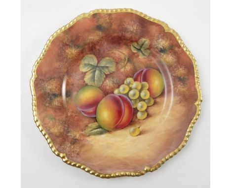 A Royal Worcester cabinet plate, hand painted with fruit to a mossy background by J Smith, with shaped gilt edge, diameter 10