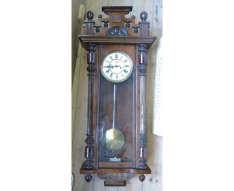 A 19th century walnut cased Vienna style wall clock, with white enamel dial and Roman numerals, the pediment with eagle over 