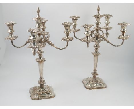 A pair of Mappin and Webb silver five light candelabra, with four scroll branches,  embossed flower and scroll decoration, ra