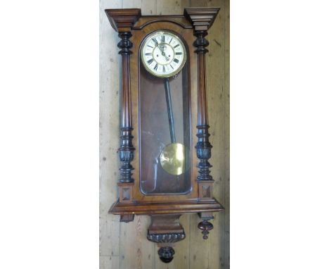 A 19th century walnut cased Vienna style wall clock, with white enamel dial and Roman numerals, the pediment with eagle over 