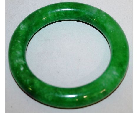 A CHINESE GREEN JADE-LIKE BANGLE, 3.1in diameter. 