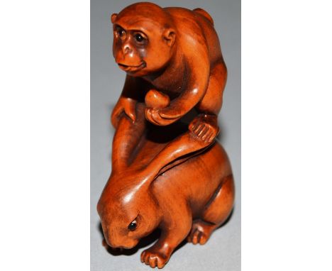 A BOXWOOD CARVED NETSUKE, A MONKEY ON A RABBIT’S BACK, signed. 