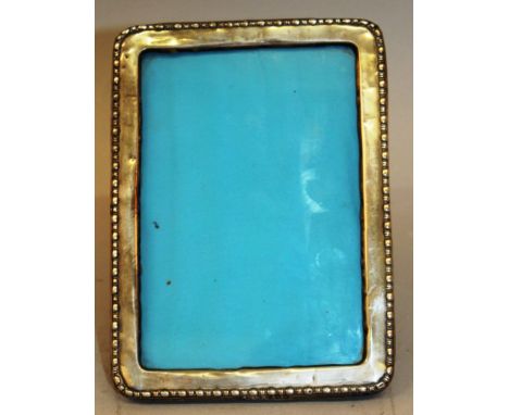 AN UPRIGHT EASEL PHOTOGRAPH FRAME with bead edge. 6.5ins high x 4.5ins wide. Birmingham 1924.