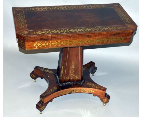 A SUPERB REGENCY ROSEWOOD BRASS INLAID CARD TABLE with folding top and blue baize interior, centre column support, shaped pla