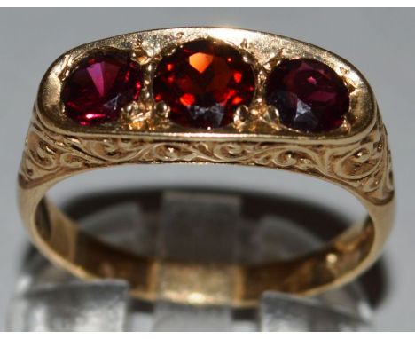 A THREE STONE RUBY RING set in 9ct yellow gold. 