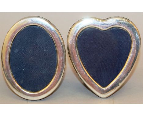 A PLAIN HEART SHAPED EASEL PHOTOGRAPH FRAME AND AN OVAL PHOTOGRAPH FRAME. (2)