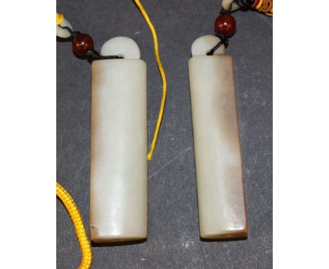 A PAIR OF CHINESE JADE PENDANTS, with tassel attachments and possibly costume accessories, each pendant 2.9in high. 