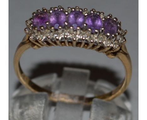 A DIAMOND AND AMETHYST RING set in 9ct yellow gold. 