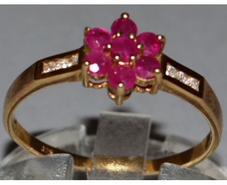 A RUBY AND DIAMOND CLUSTER RING set in 9ct yellow gold. 