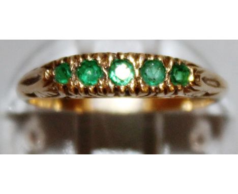 A FIVE STONE EMERALD GOLD SET RING. 