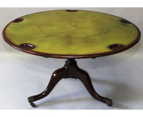 A GEORGE IV MAHOGANY GAMING TABLE, the circular tilt top inset with a gilt tooled playing surface and five carved counter hol