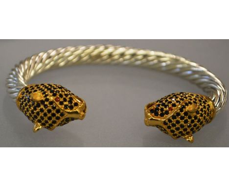 A GOOD SILVER BANGLE with PANTHER HEADS set with black cupids. 