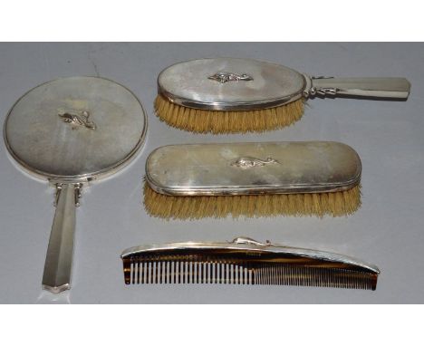 A JENSEN FOUR PIECE SILVER DRESSING TABLE SET comprising hand mirror, two brushes and comb. 