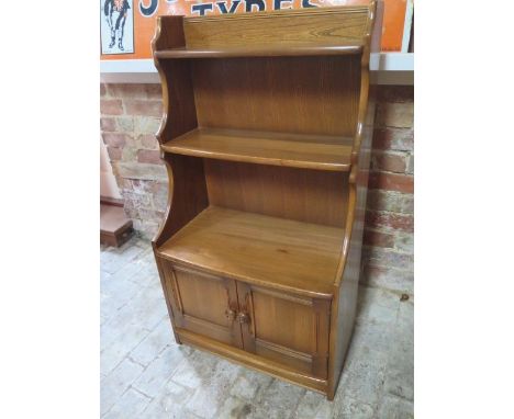 An Ercol waterfall bookcase with two base drawers - Height 102cm x Width 61cm 